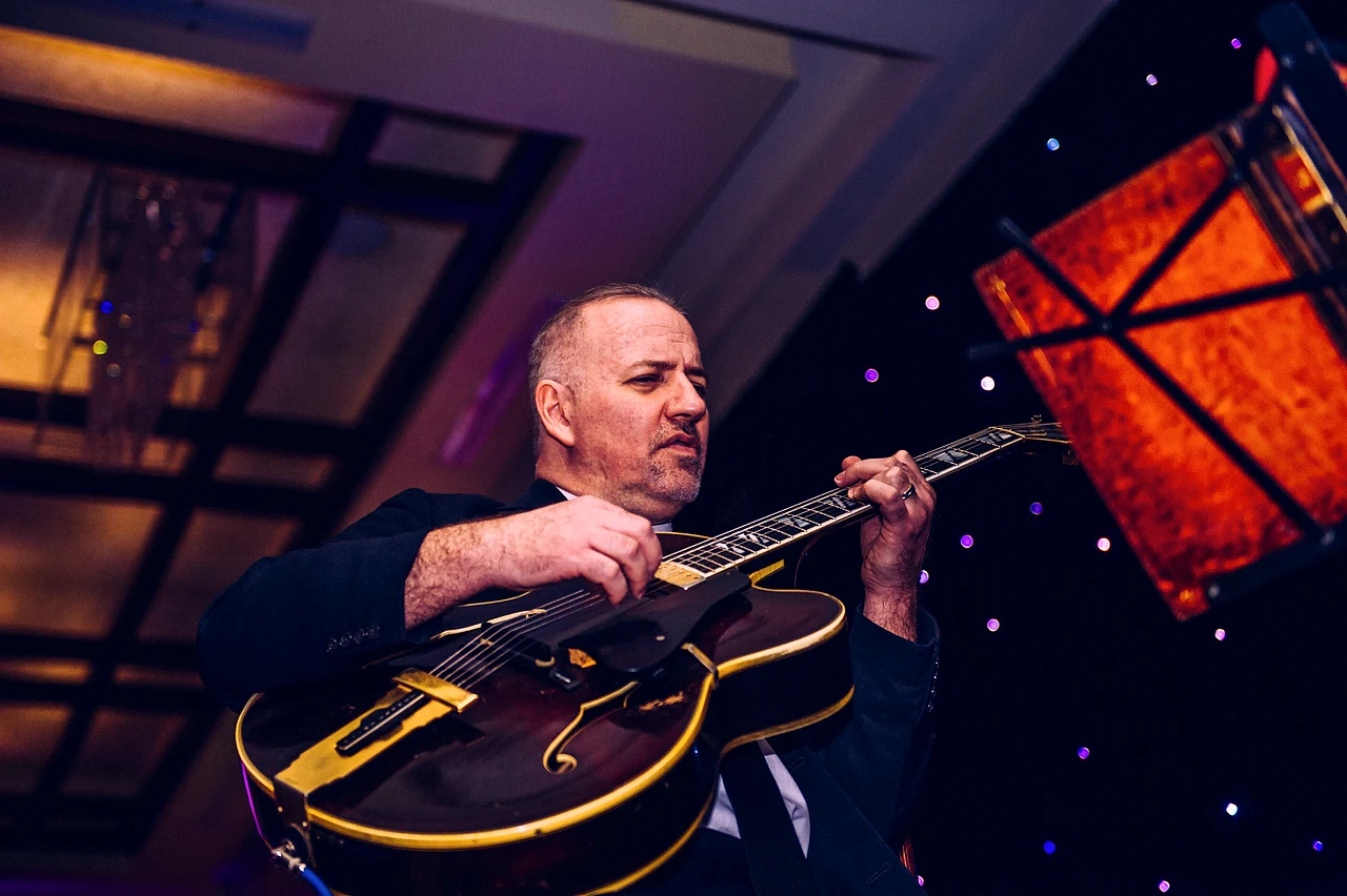Live guitarist performing at an evening event.
