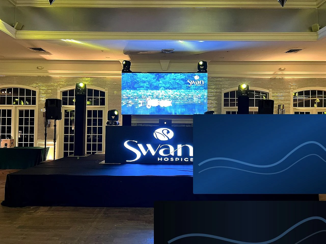 Corporate event production with professional speakers, stage lighting and a large video display.
