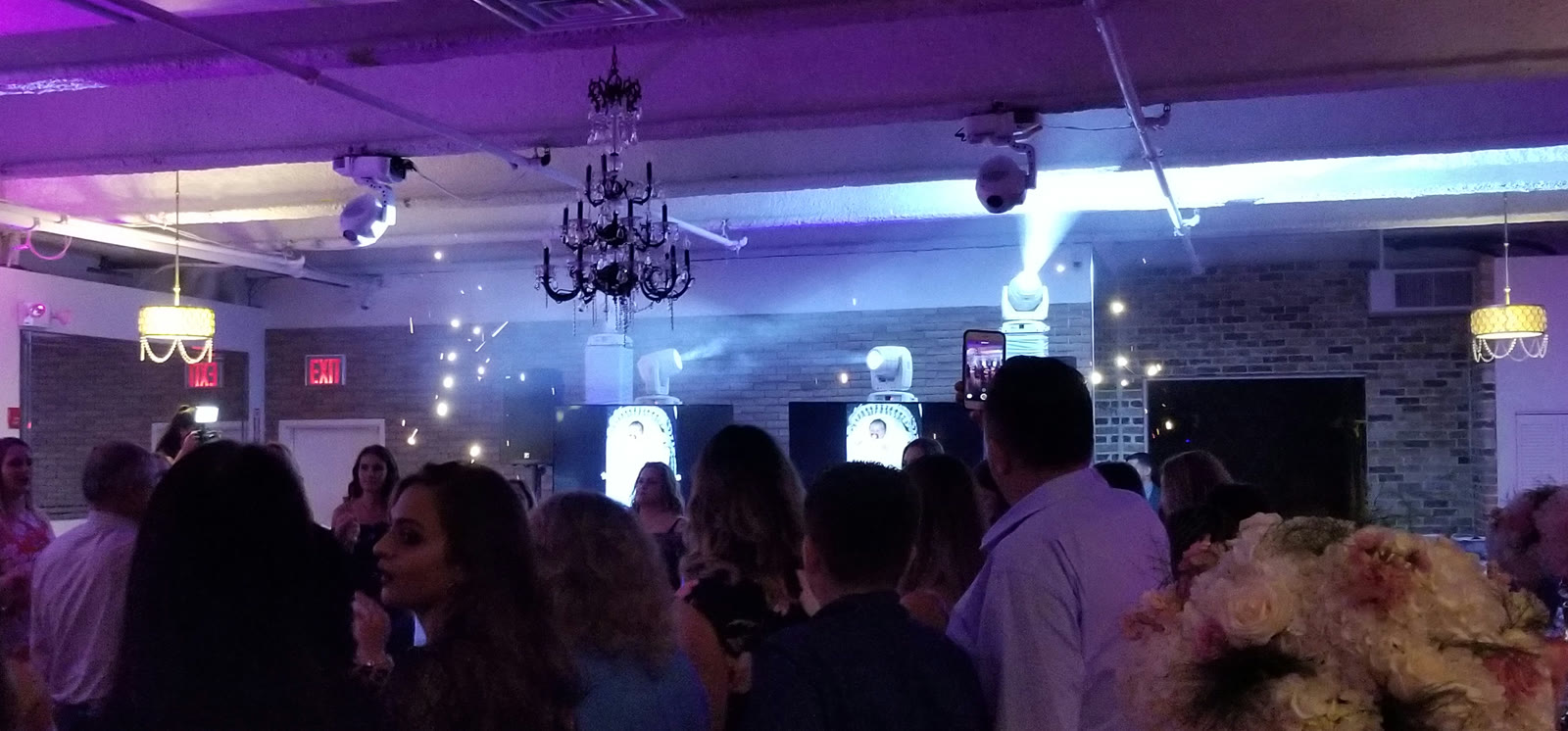Moving-head lighting creates beams above guests at an All Generations event.